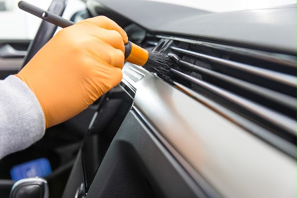 Detailreinigung der Lüftungsschlitze mit dem Pinsel